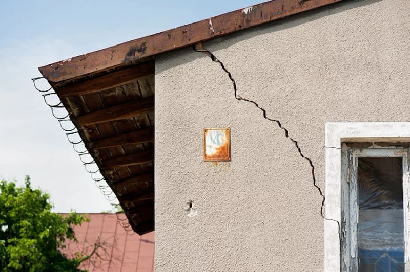 Fissure structurelle traversant la façade d'une maison